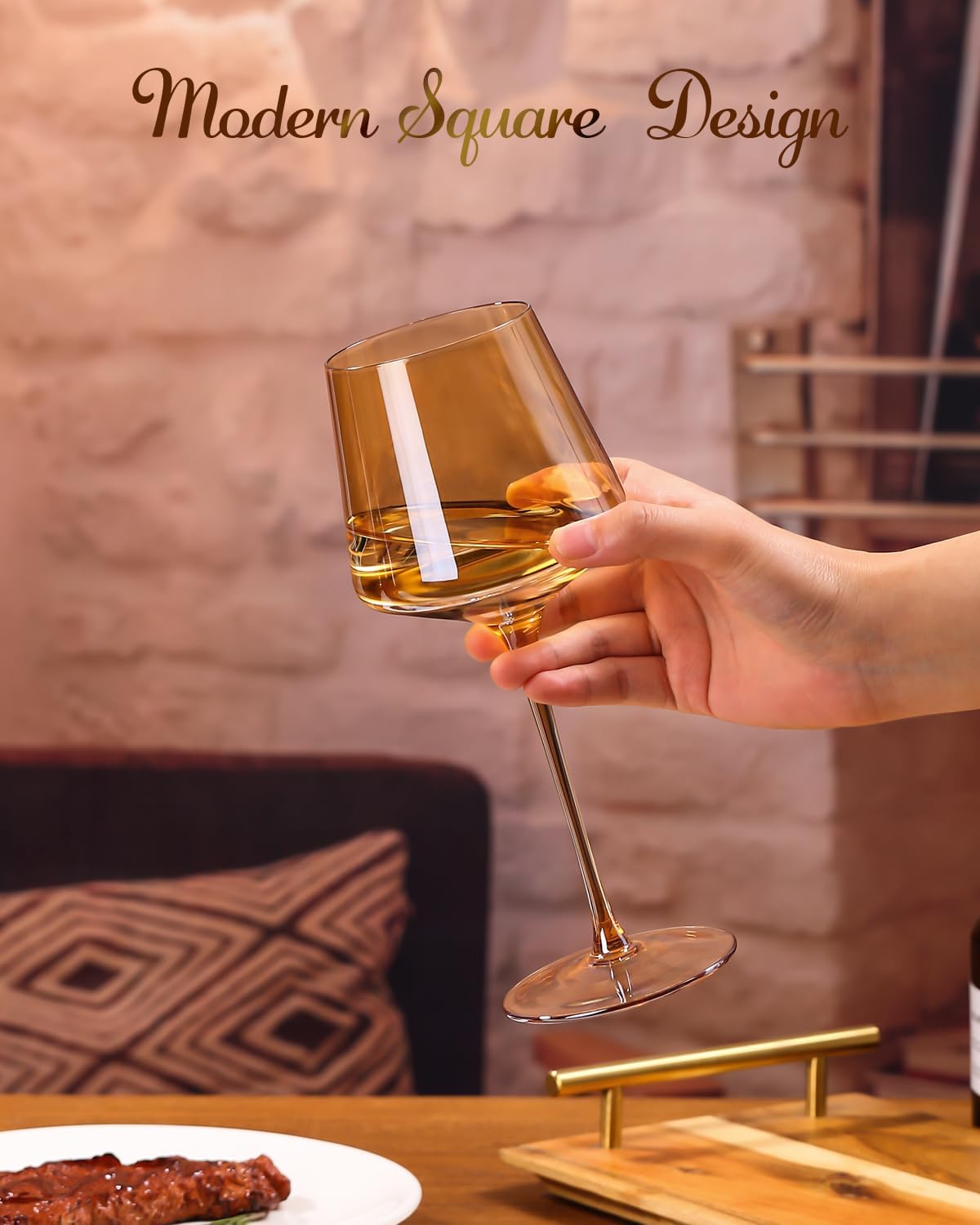 Hand holding an amber wine glass with a square-shaped bowl