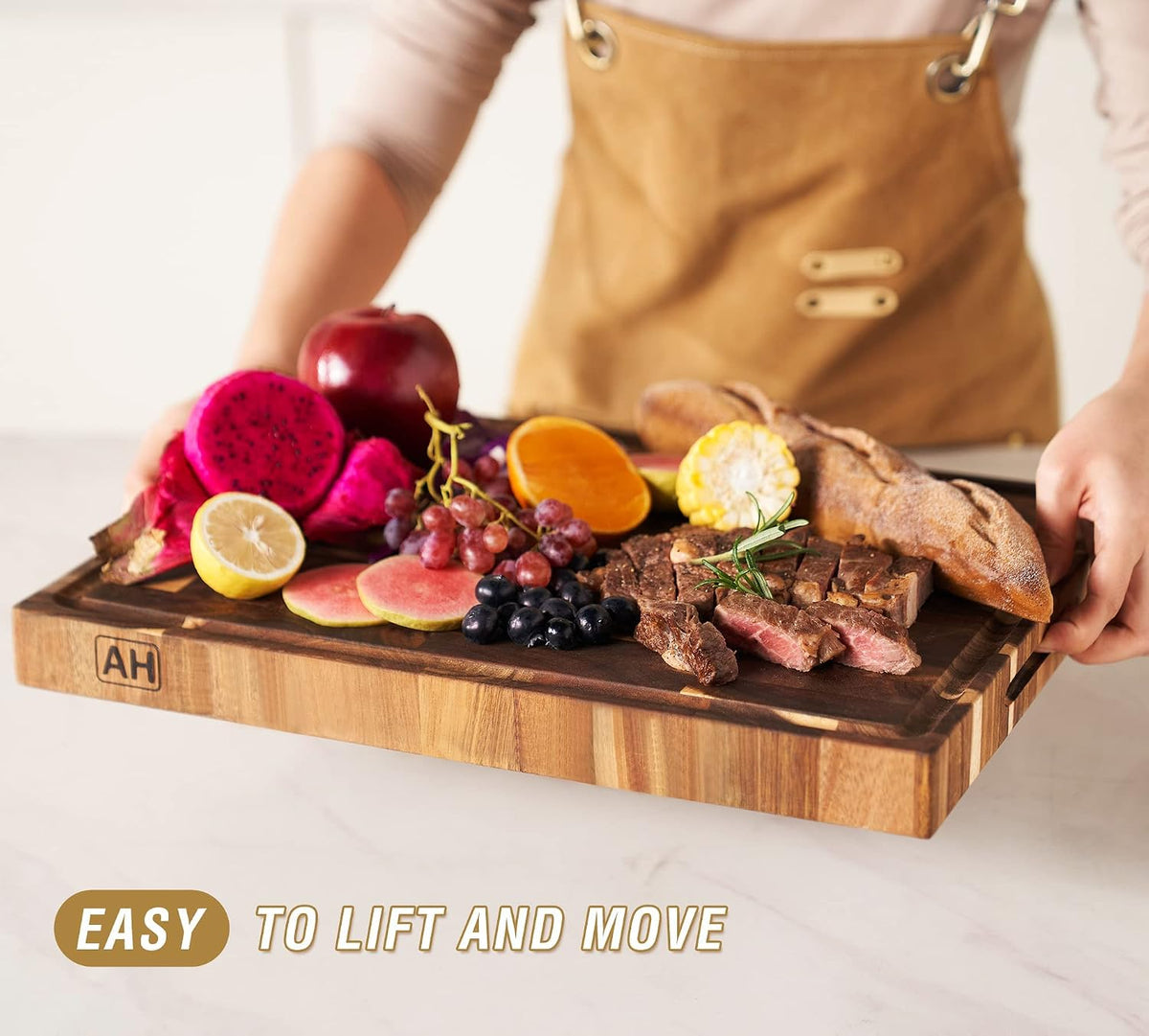 Carrying the board by its built-in handles with fruit, bread and meat on top