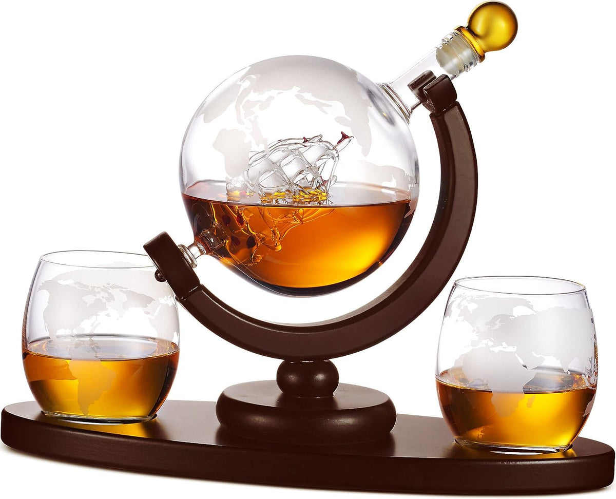 Godinger globe whiskey decanter with an etched world map and two matching glasses on a wood tray