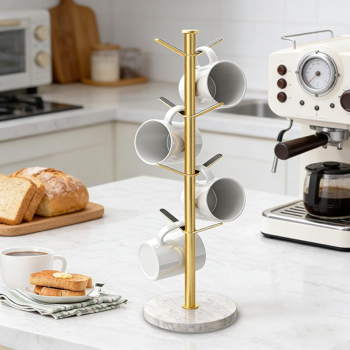 Gold mug tree with mugs on a kitchen counter beside a coffee machine
