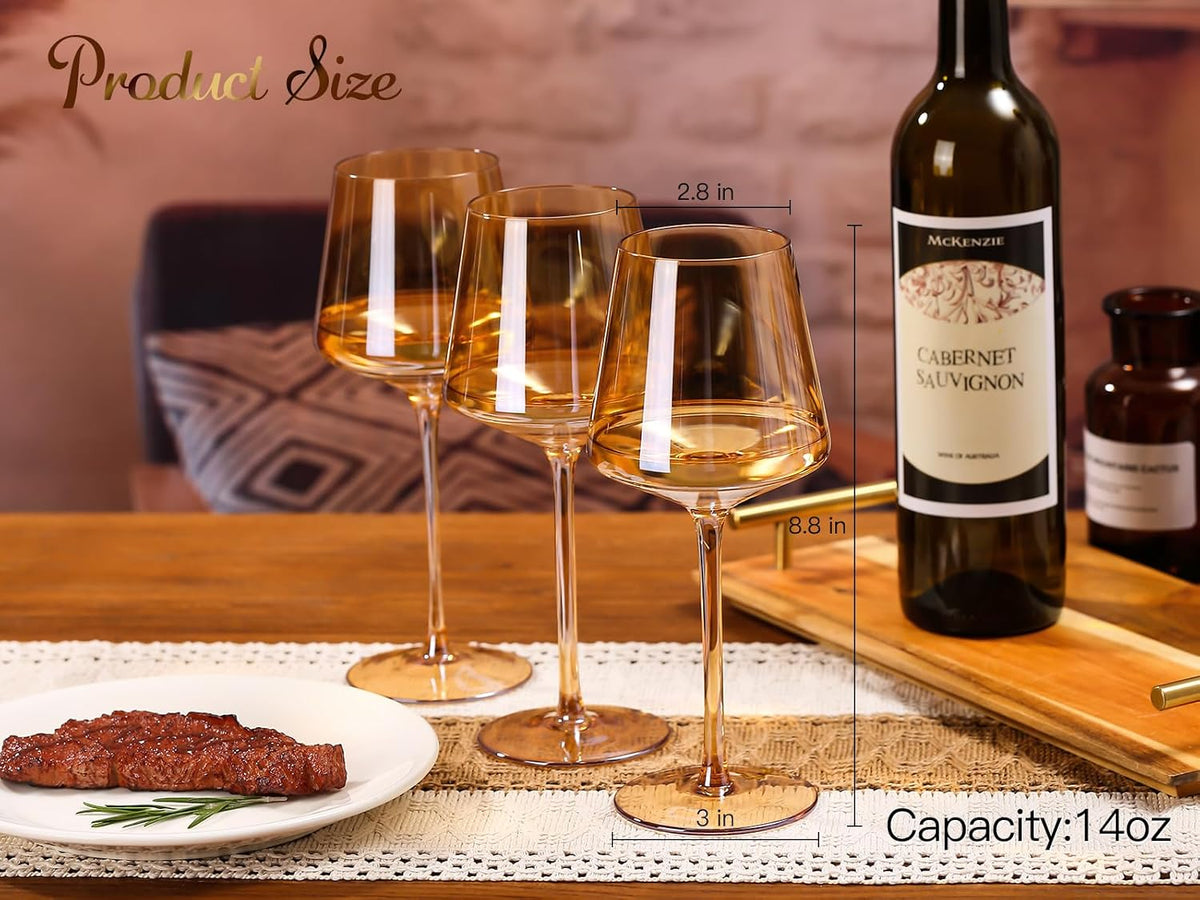 Amber wine glasses on a wooden table beside a bottle of wine