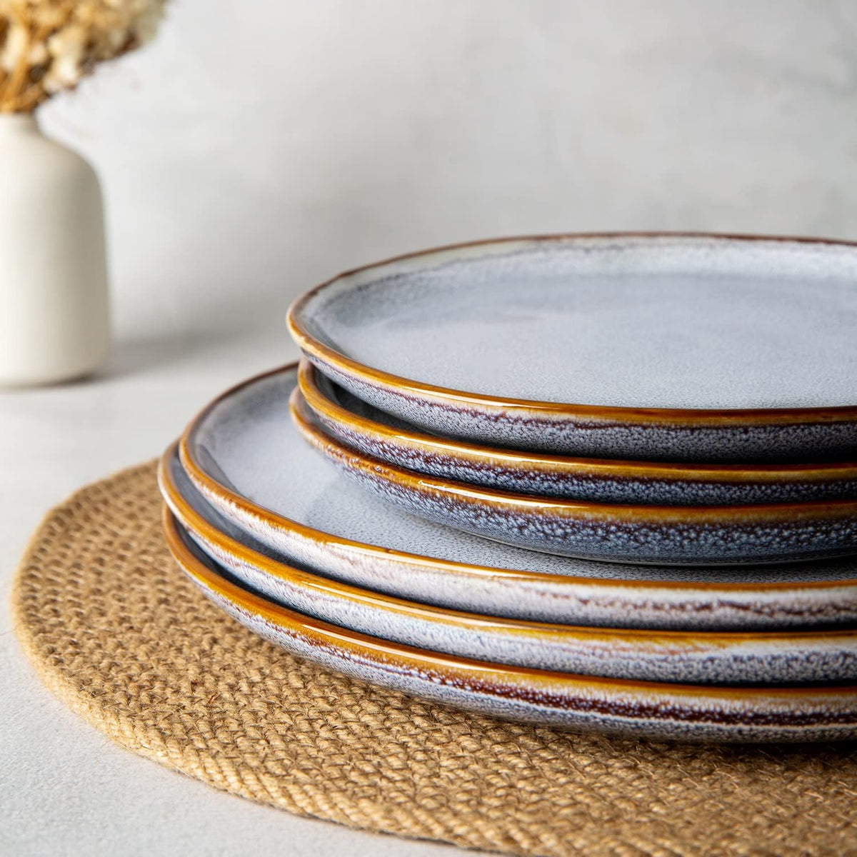 Stack of reactive-glaze stoneware plates on a woven placemat