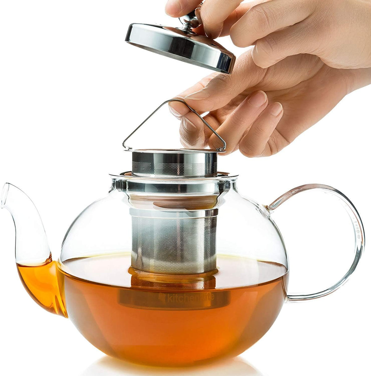 Hand lifting the infuser out of the glass teapot
