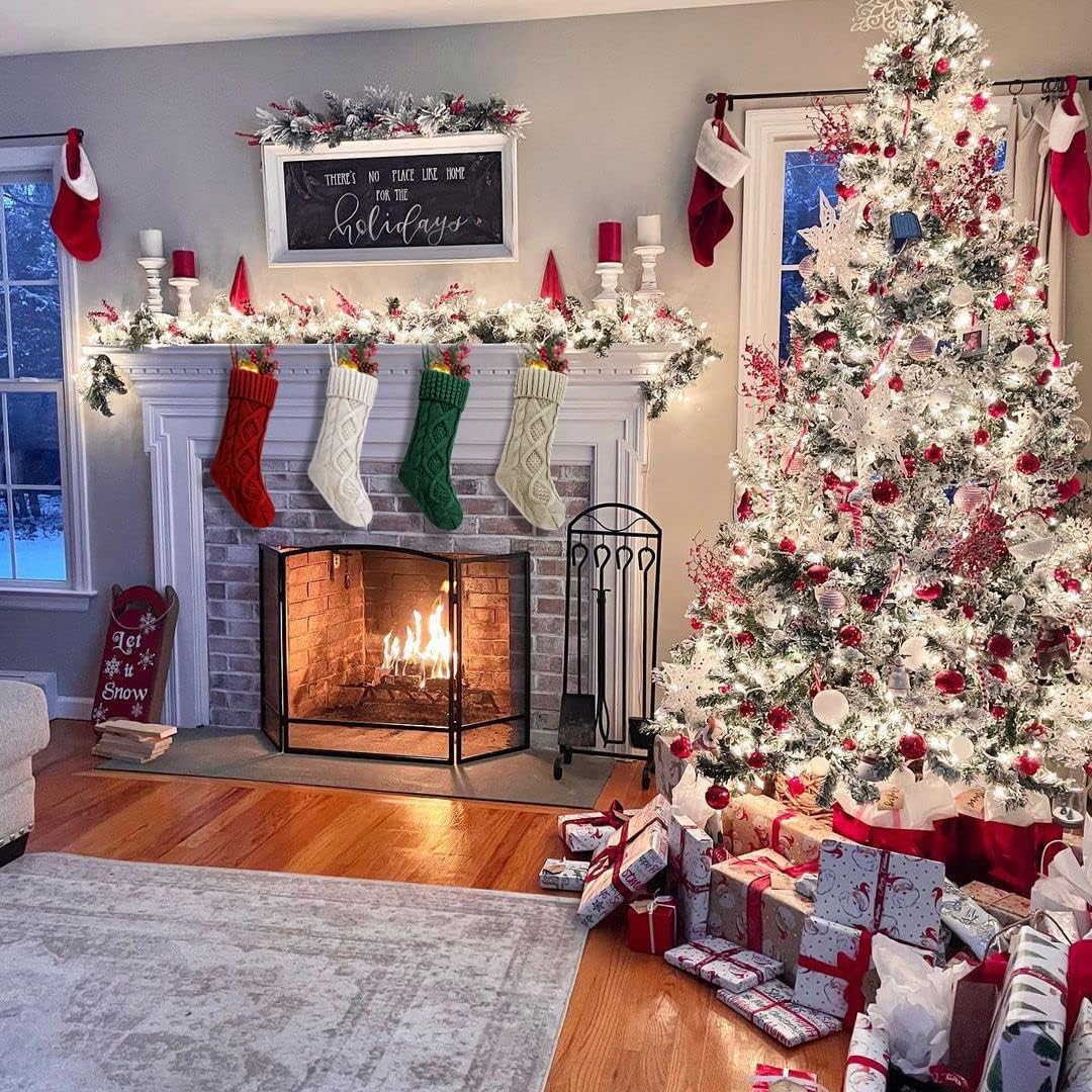 Knit stockings on a white fireplace mantel next to a flocked tree