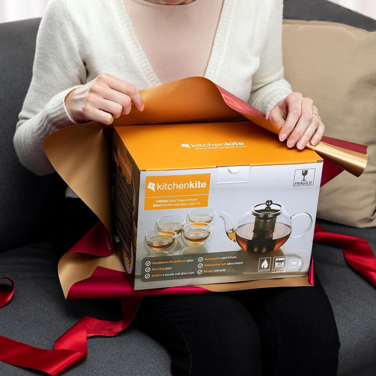Person unwrapping the boxed glass teapot set