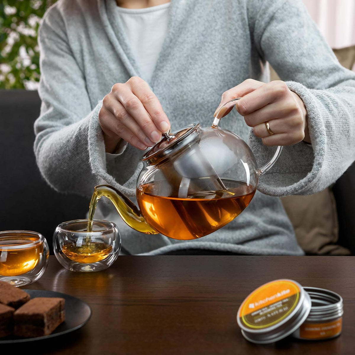 Pouring tea from the glass teapot into a double-wall cup