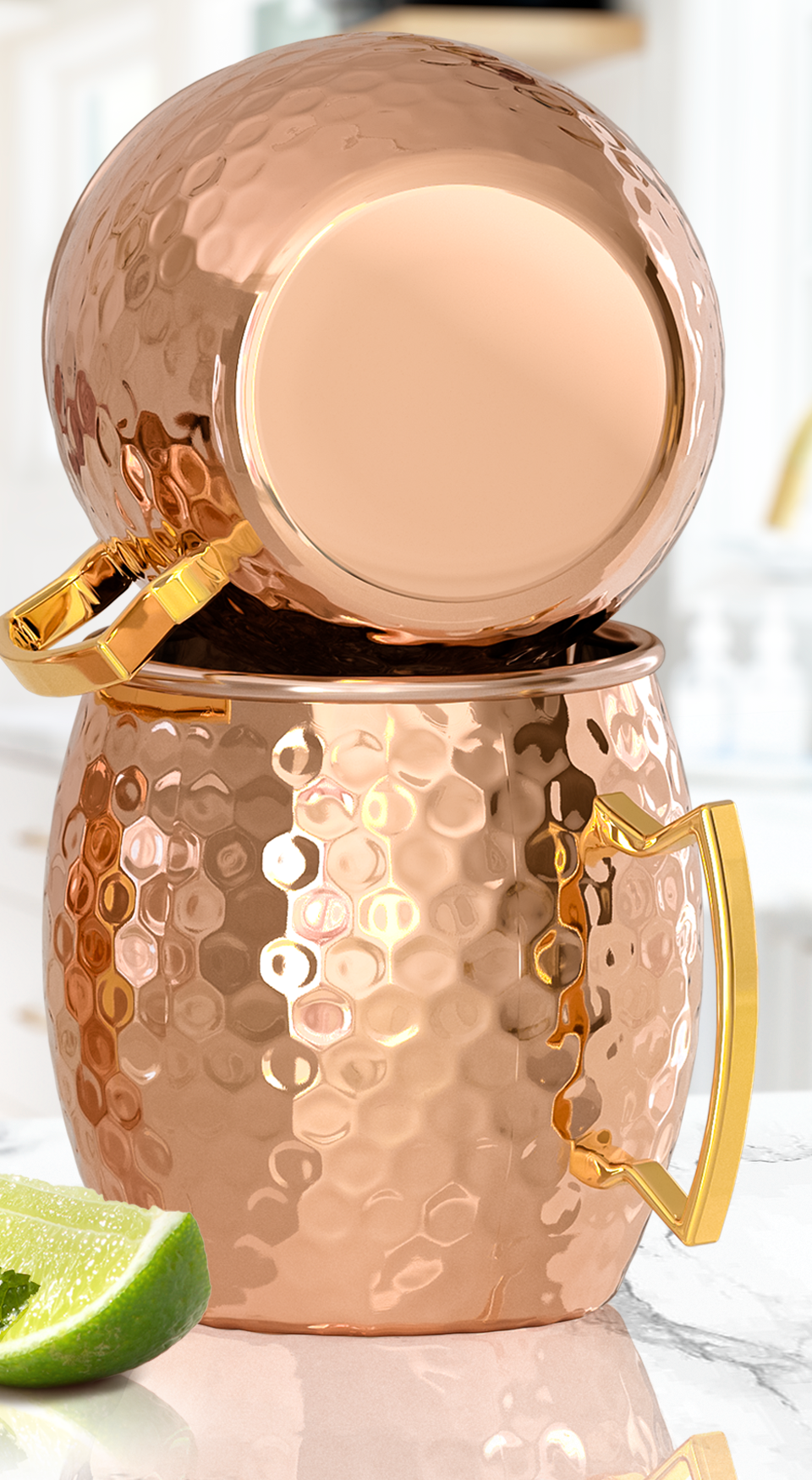 Two hammered copper Moscow mule mugs stacked, showing the smooth base