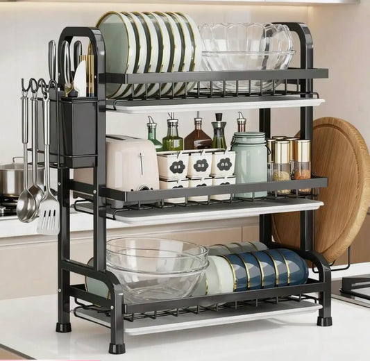 3-tier stainless steel dish drying rack with plates, bowls, and utensils on kitchen counter
