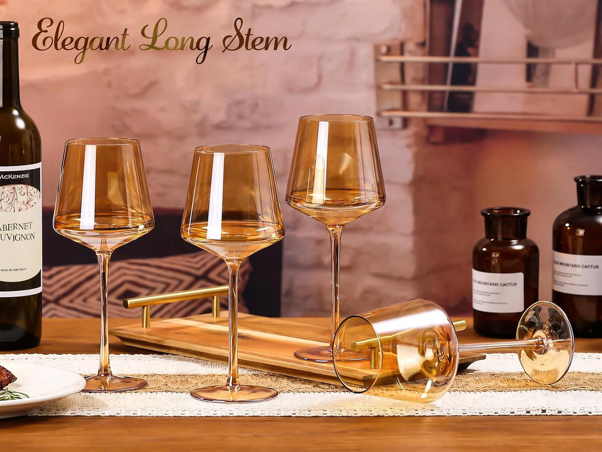 Three amber wine glasses with long stems on a wooden tray