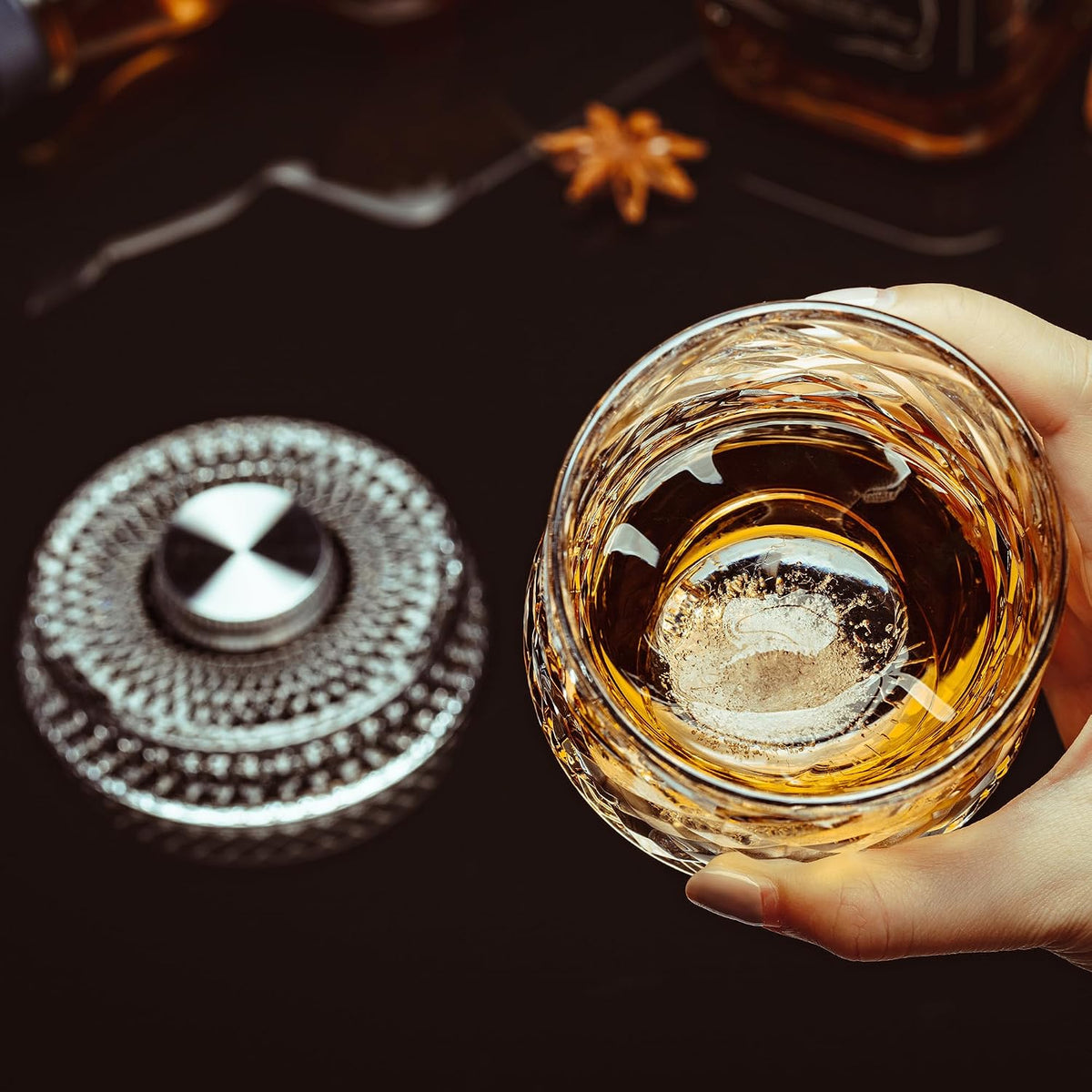 Hand holding the glass above its rotating base