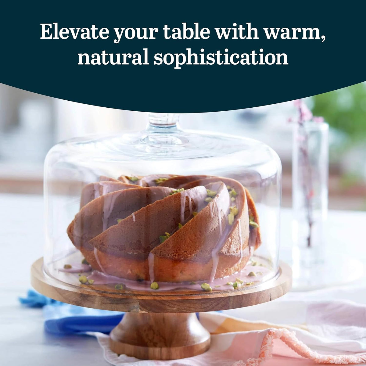 Bundt cake under the glass dome of the acacia wood cake stand
