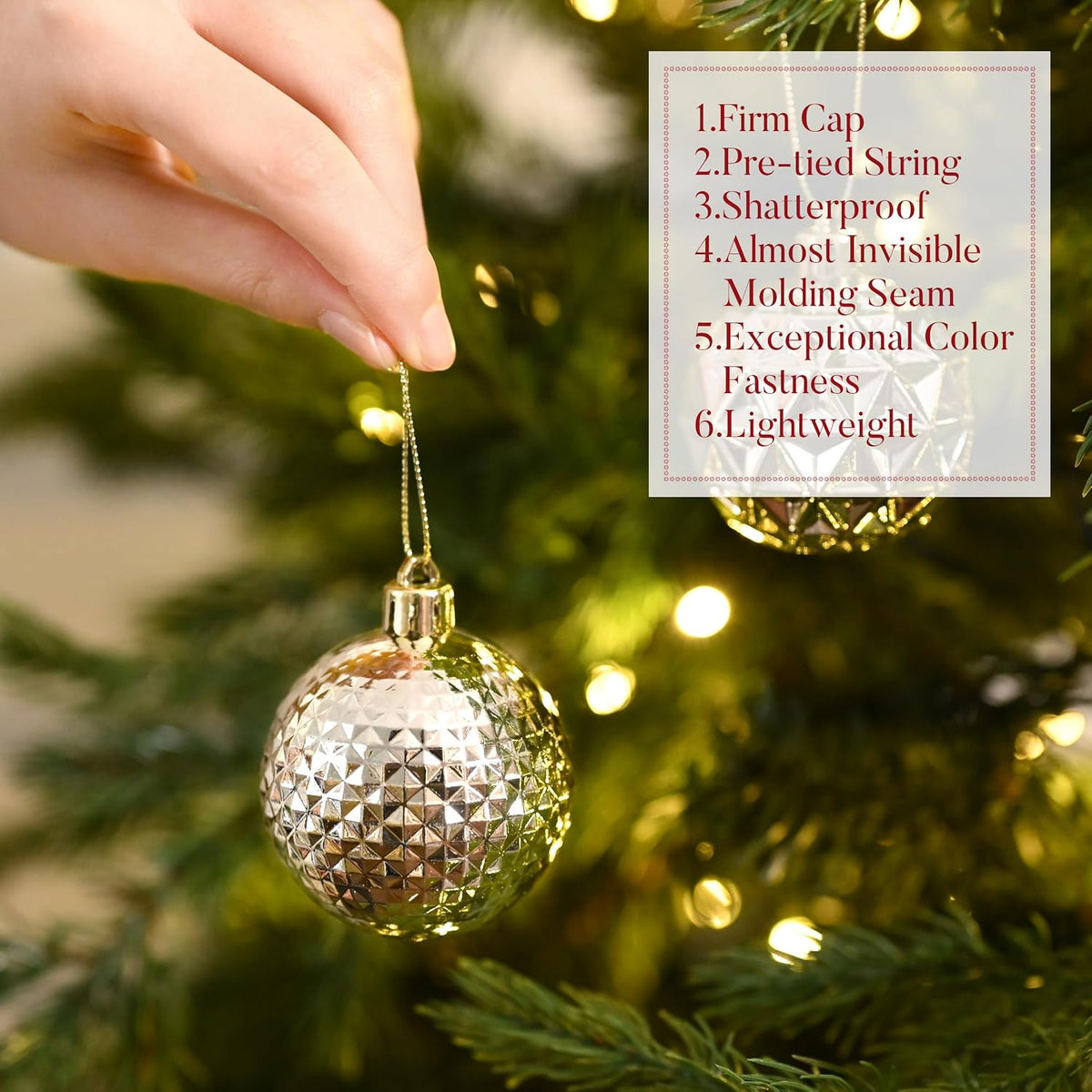 Hand hanging a faceted champagne ornament on a tree