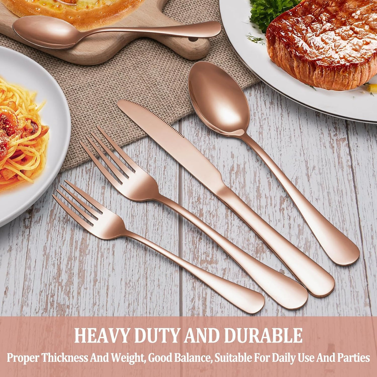Rose gold flatware on a wooden table beside plates of food
