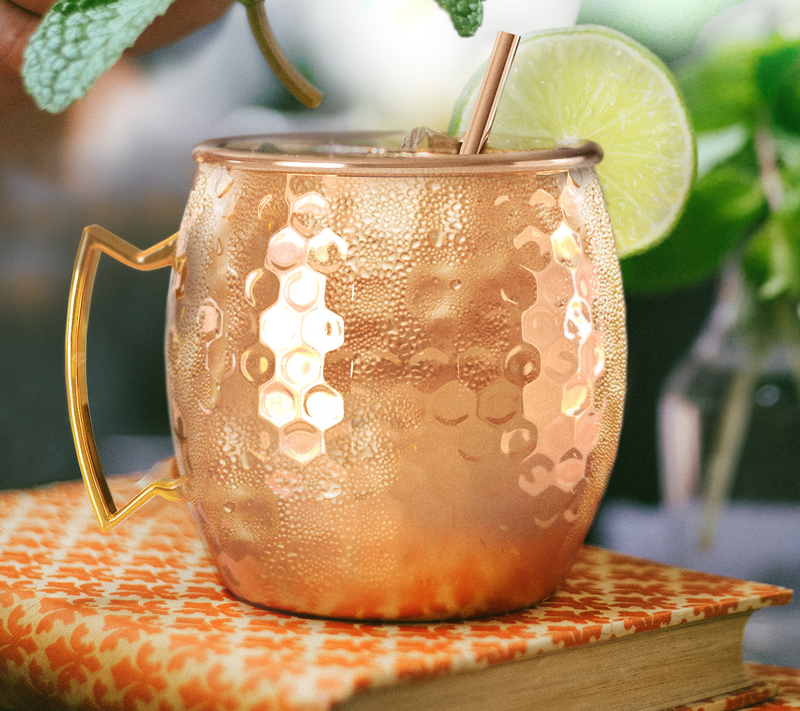 Hammered copper Moscow mule mug with lime and a copper straw