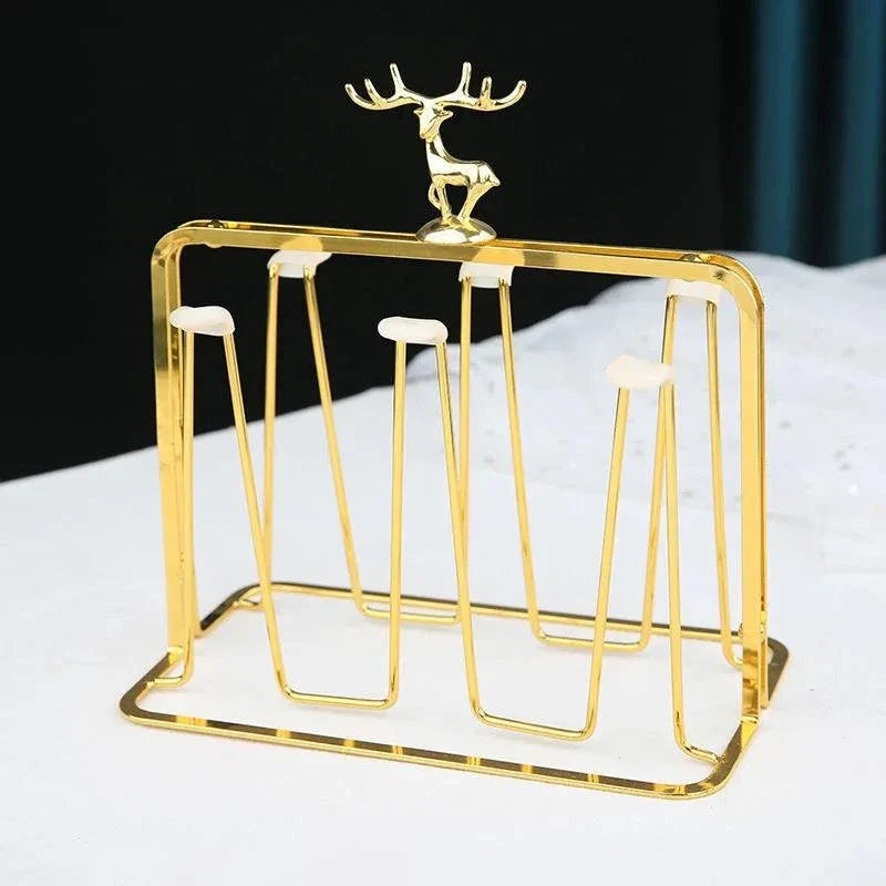Gold glass mug organizer with gold metal frame and decorative deer accent on countertop