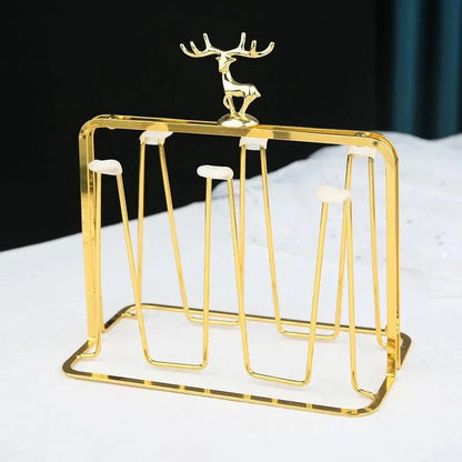 Gold glass mug organizer with gold metal frame and decorative deer accent on countertop
