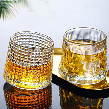 Rotating whiskey tumblers filled with bourbon and ice, perfect for home bars
